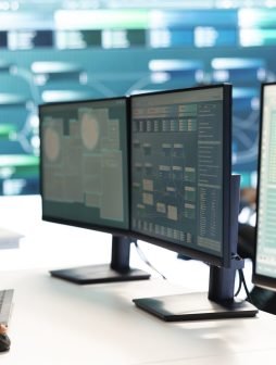 Governmental hacker investigating cyber incidents and monitoring security threats on a big screen. Woman specialist uses phishing techniques to steal important information for cyberwarfare.